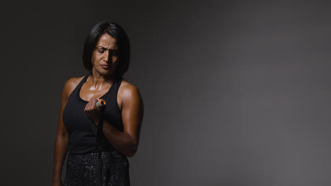 Foto-De-Estudio-De-Una-Mujer-Madura-Vistiendo-Ropa-De-Gimnasio-Haciendo-Ejercicio-Con-Banda-De-Resistencia-2